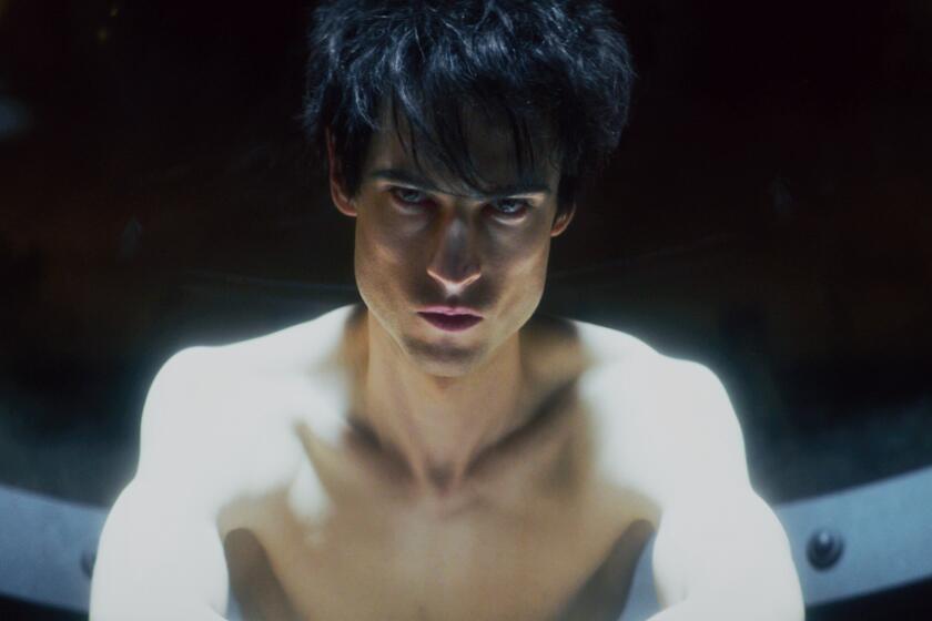 A pale, shirtless young man with chiseled cheekbones and dark hair