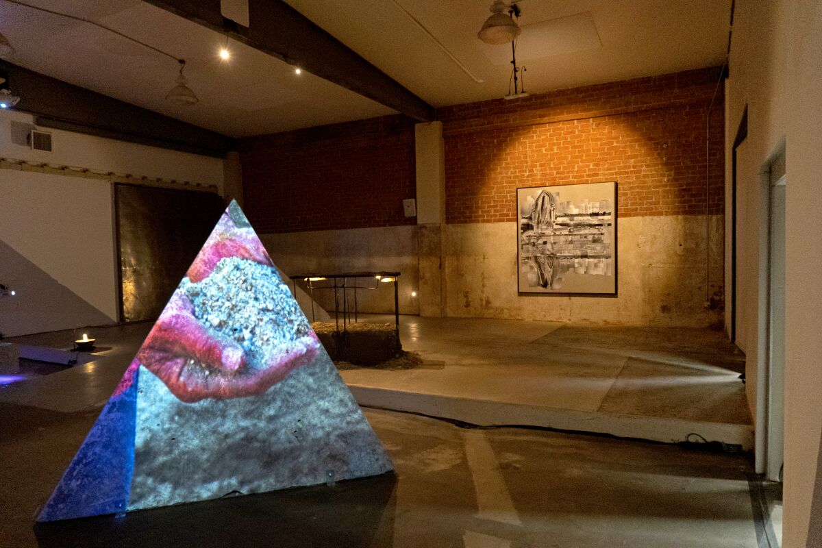A pair of hands holding dirt projected on a prism.