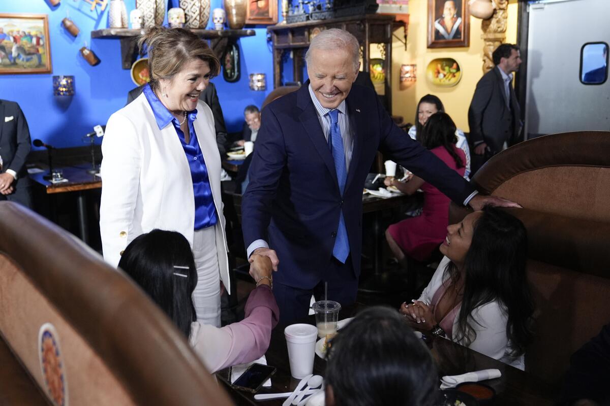 President Biden greets patrons sitting in a restaurant booth in Las Vegas.