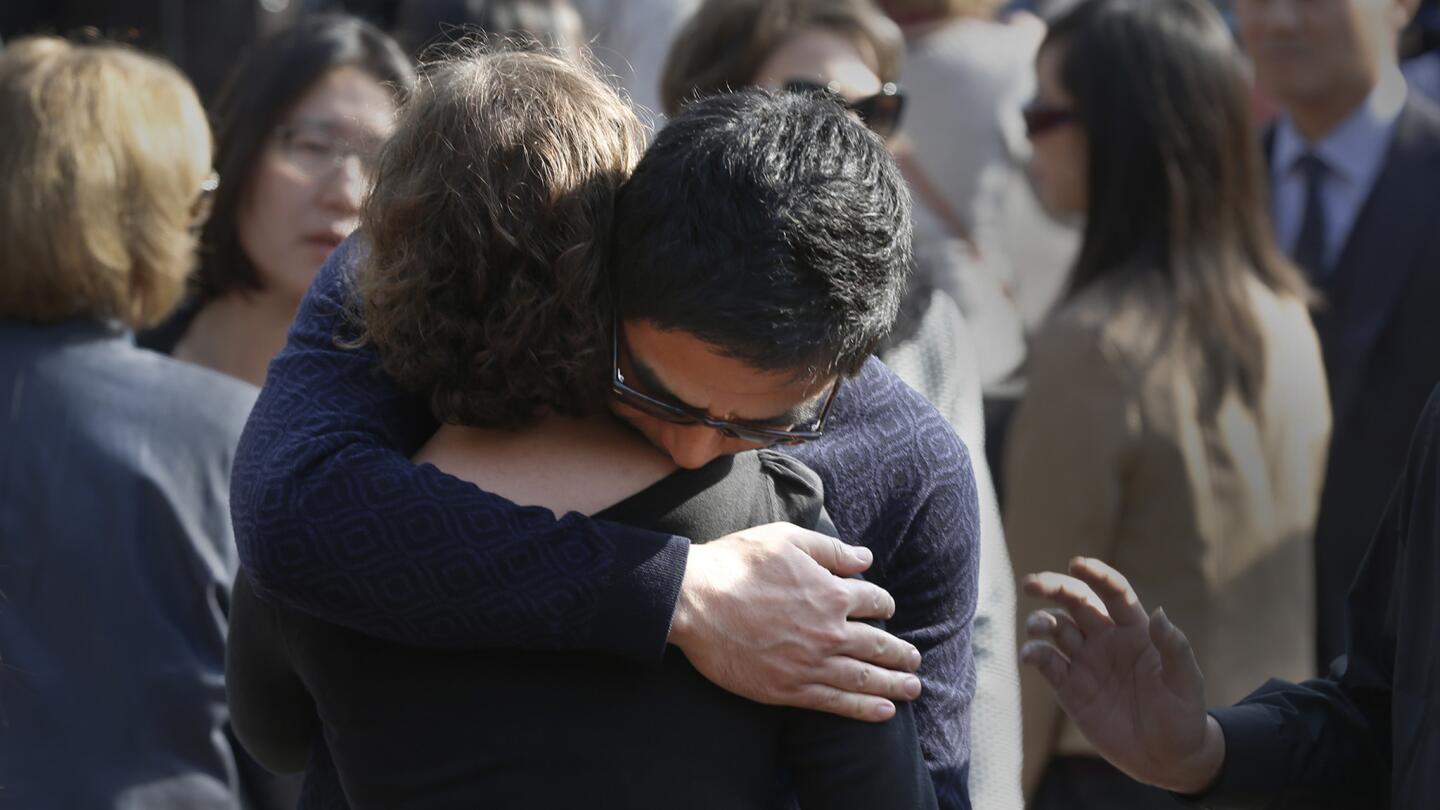 Mourners embrace during a remembrance ceremony for USC psychology professor Bosco Tjan.