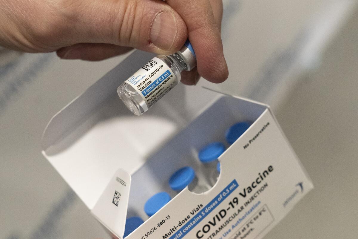A pharmacist holds a vial of the Johnson & Johnson COVID-19 vaccine. 