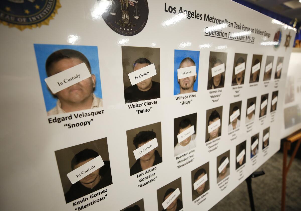 A poster shows defendants in custody as law enforcement officials announce the unsealing of a federal racketeering indictment targeting Los Angeles-based members of the MS-13 gang on July 16.