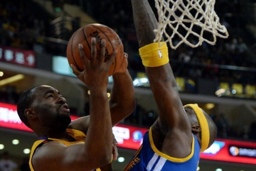 Lakers forward Marcus Landry is blocked by Golden State Warriors' Jermaine O'Neal during an exhibition game Tuesday in Beijing.