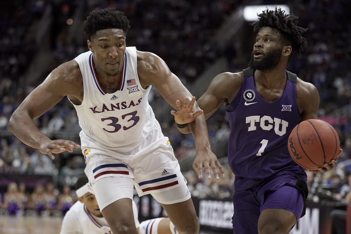 TCU guard Mike Miles (1) drives under pressure from Kansas forward David McCormack (33) during the first half of an NCAA college basketball game in the semifinal round of the Big 12 Conference tournament in Kansas City, Mo., Friday, March 11, 2022. (AP Photo/Charlie Riedel)