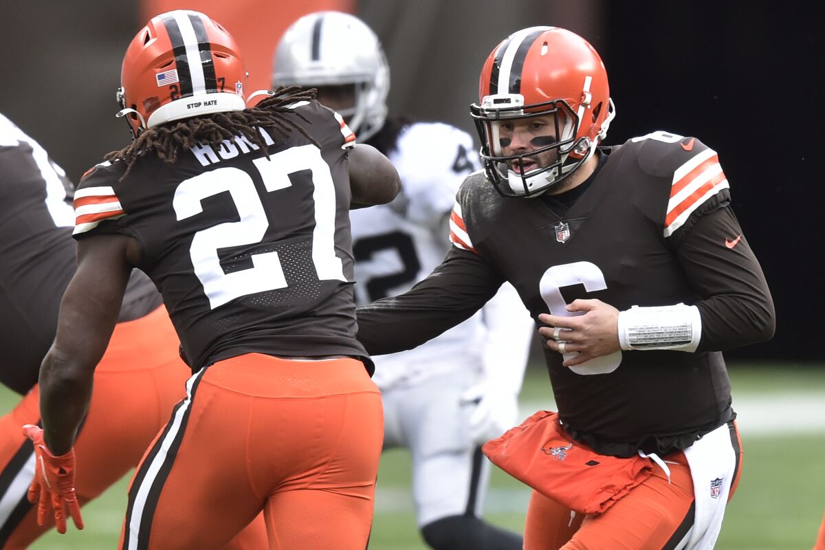 Cleveland Browns quarterback Baker Mayfield (6) hands the ball off to running back Kareem Hunt (27) during the first half of an NFL football game against the Las Vegas Raiders, Sunday, Nov. 1, 2020, in Cleveland. (AP Photo/David Richard)