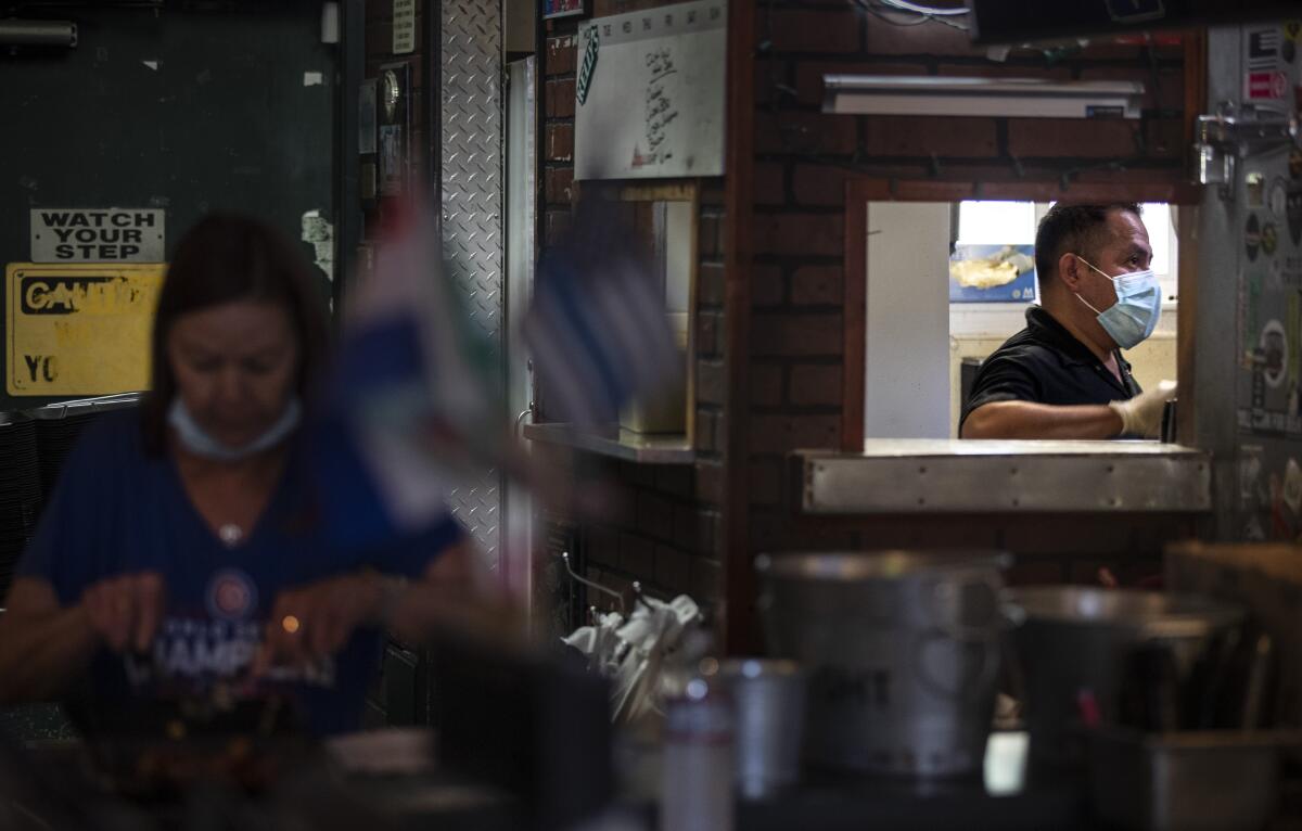 Bartender Julie Radtke and chef Miguel Barrow  prepare takeout orders at Kelly's Korner Tavern.