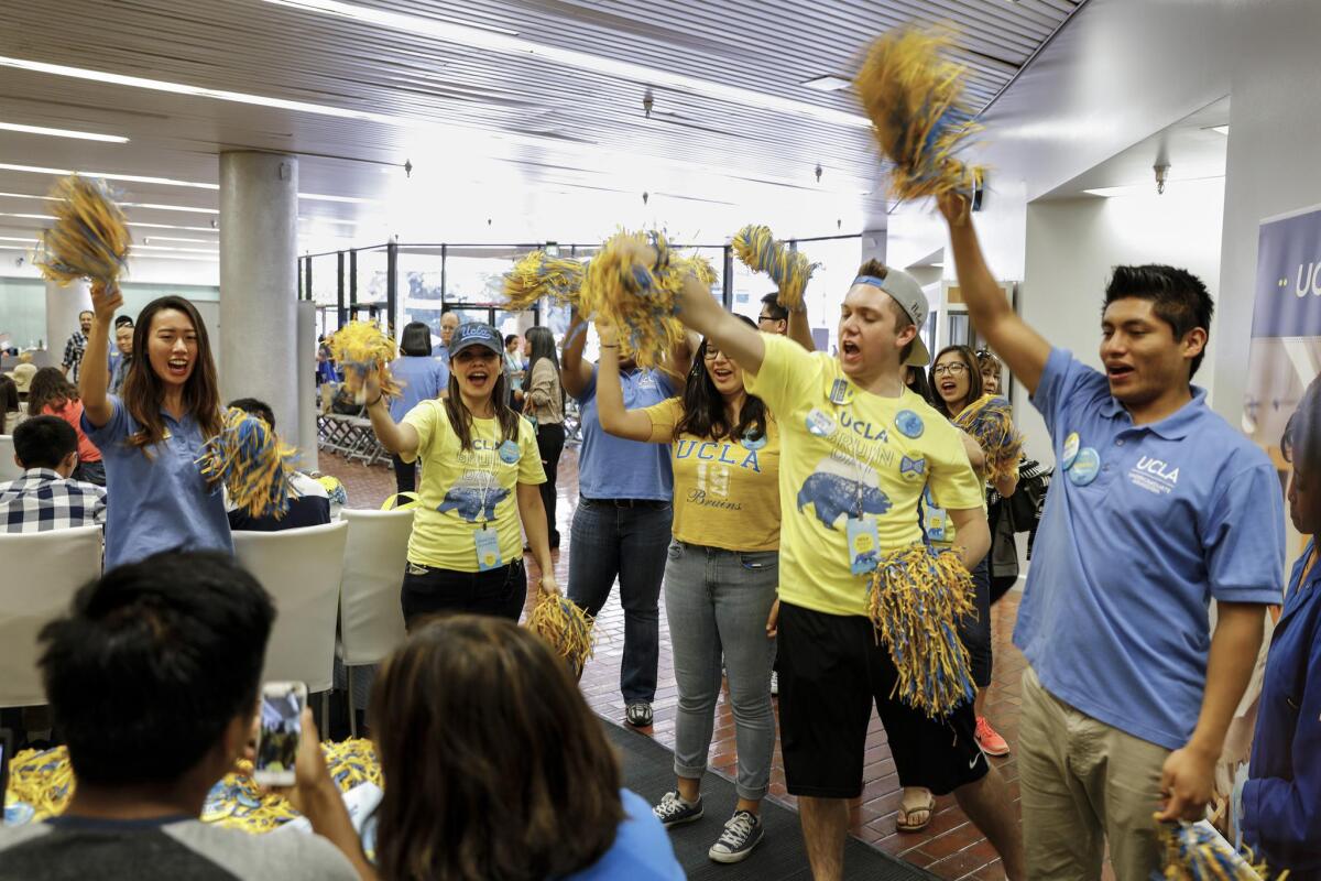 Students and staff cheer on a student after he completes his intent to enroll at UCLA during Bruins Day, when the school welcomes to campus all admitted students.