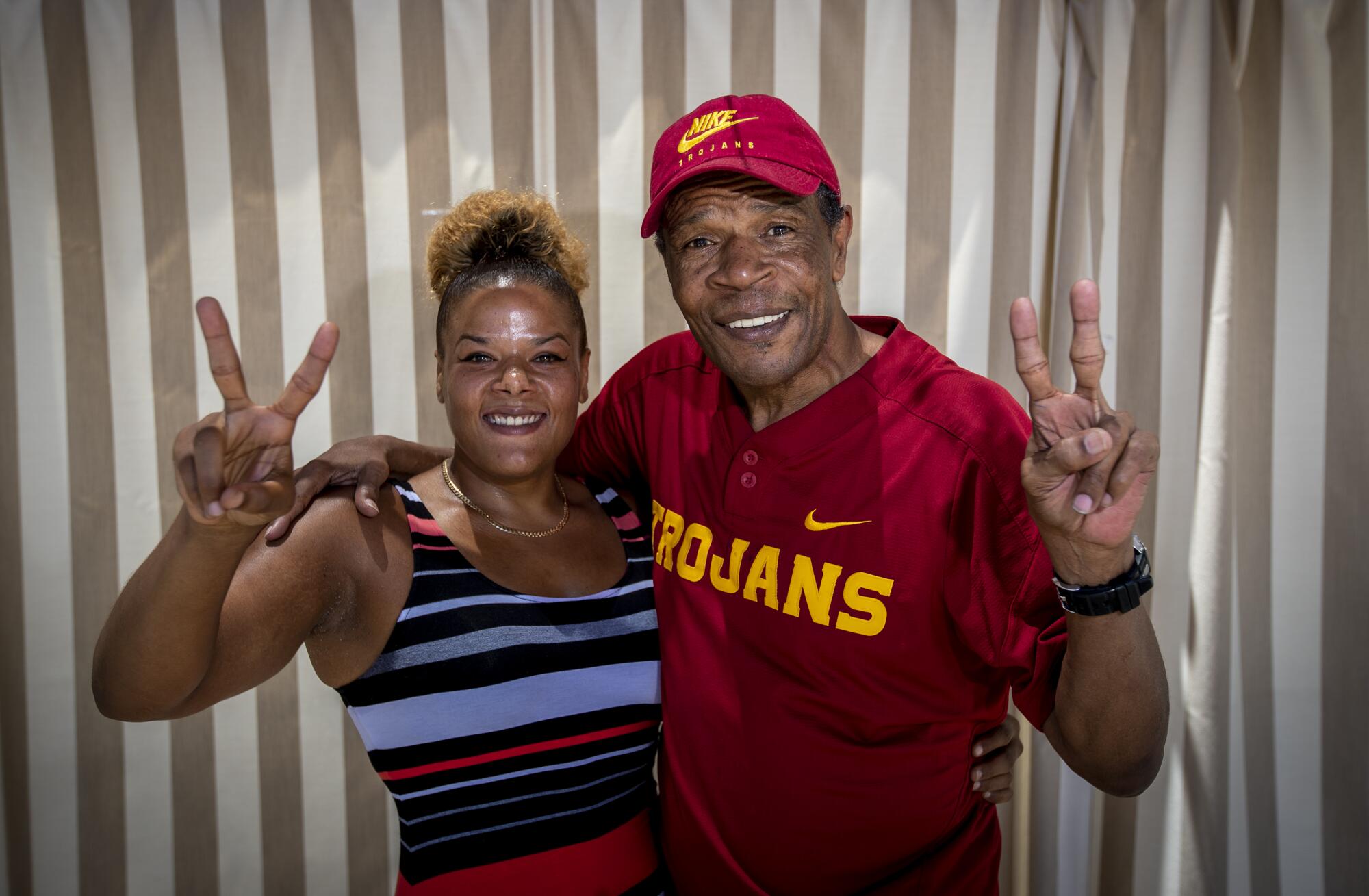 USC great Charles White and his daughter, Tara White, give the Trojan victory salute.