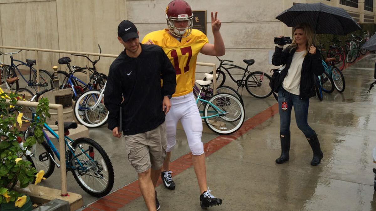 Jake Olson walks to the Trojans practice field on Tuesday.