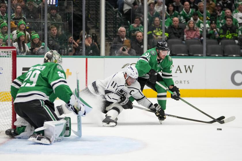 Los Angeles Kings center Anze Kopitar, center, attacks as Dallas Stars center Matt Duchene (95) and goaltender Jake Oettinger (29) defend their net during the second period of an NHL hockey game, Tuesday, Jan. 16, 2024, in Dallas. (AP Photo/Julio Cortez)