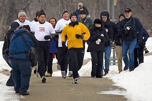 Former Arkansas governor and GOP presidential hopeful Mike Huckabee, center, jogs along Gray's Lake in Des Moines.