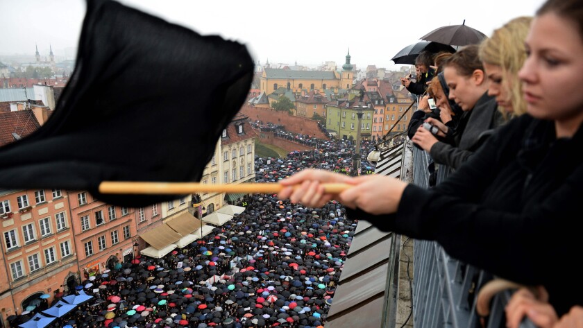 A girl waves a black flag as people take part in a nationwide strike and demonstration to protest against a legislative proposal for a total ban of abortion on Oct. 3, 2016, in Warsaw.