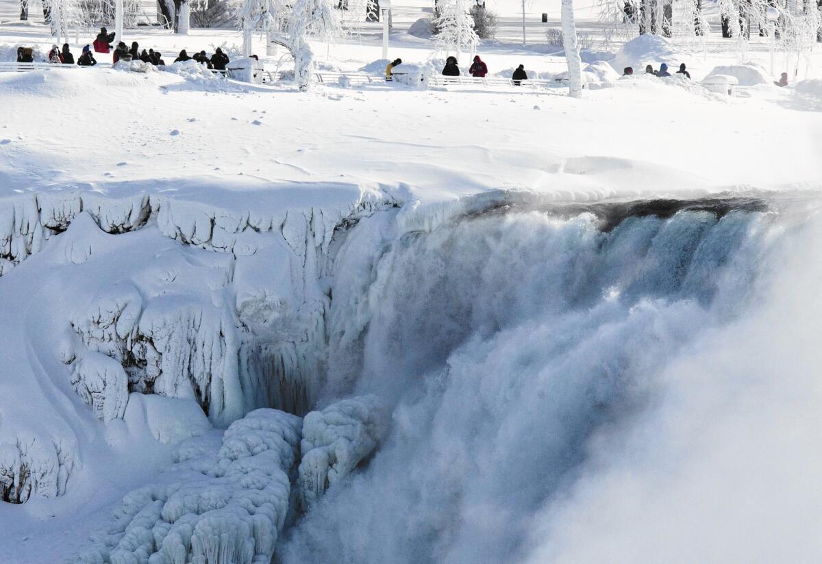 Visitors to Niagara Falls State Park look over masses of ice formed around the American side of the natural landmark. In a winter of extremes, life on the West Coast and the East Coast has been very different of late.