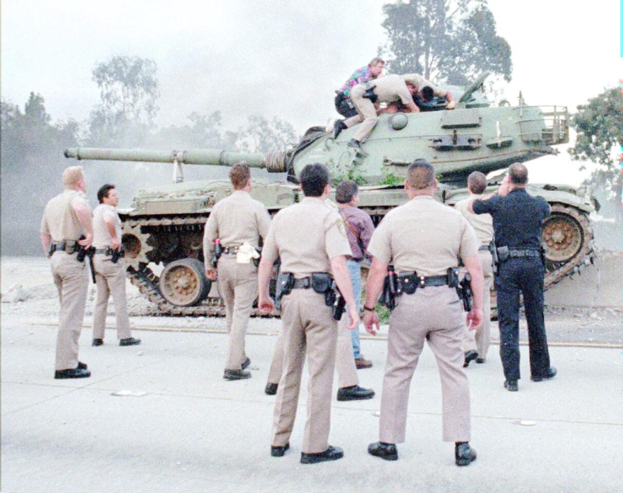 San Diego police and California Highway Patrol officers work to stop an M-60 tank that was hijacked from a National Guard armory in 1995. The man who hijacked the tank was shot and killed by police.