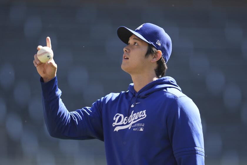 Los Angeles Dodgers' Shohei Ohtani gestures on the field before a baseball game against the Minnesota Twins, Wednesday, April 10, 2024, in Minneapolis. (AP Photo/Abbie Parr)