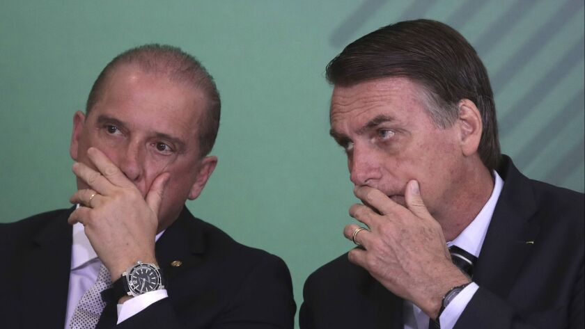 Brazilian President Jair Bolsonaro, right, talks with his chief of staff, Onyx Lorenzoni, during a Cabinet presentation ceremony at the presidential palace in Brasilia on Wednesday.