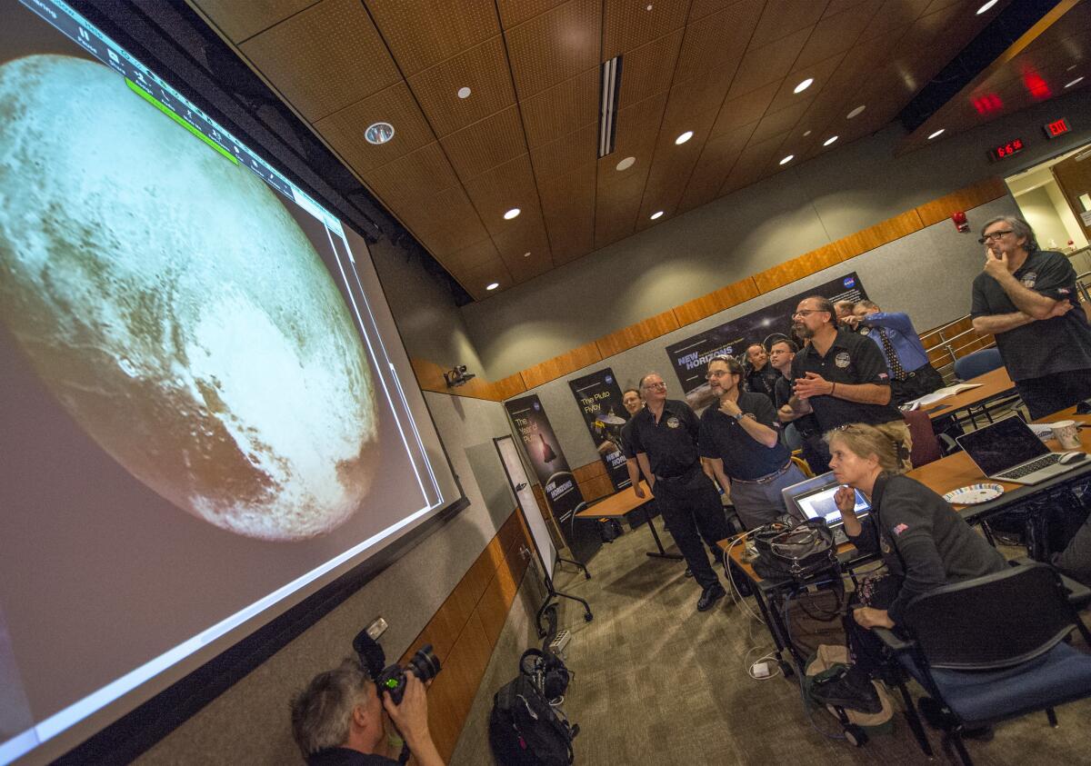 Miembros del equipo científico New Horizons aplauden al ver la imagen más nítida de Plutón antes de su acercamiento máximo el martes 14 de julio de 2015 en el Laboratorio de Física Aplicada de la Universidad Johns Hopkins en Laurel, Maryland.