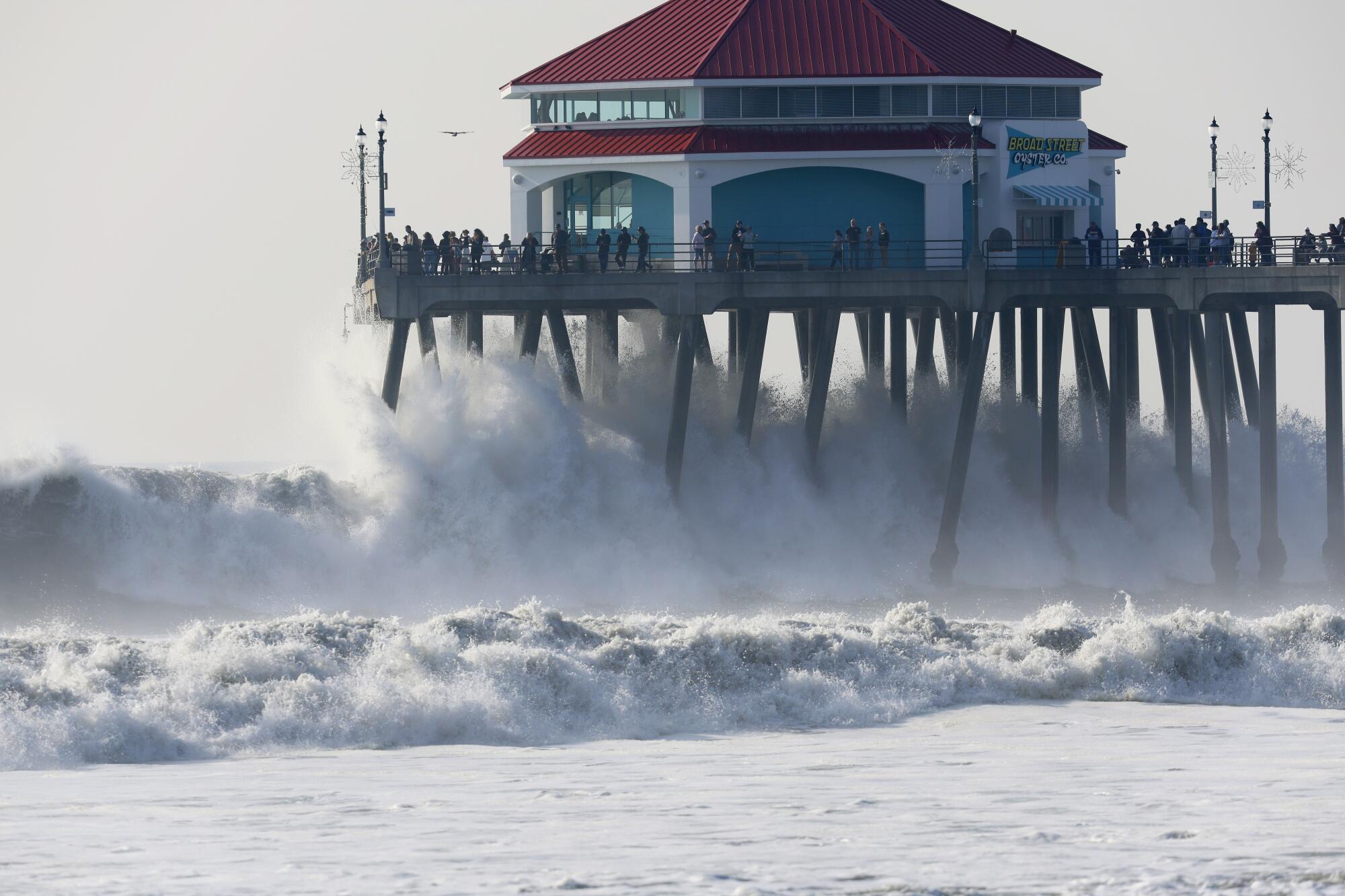 High surf reaches the bottom of the Huntington Beach Pier as spectators get a close-up look at the powerful swell.