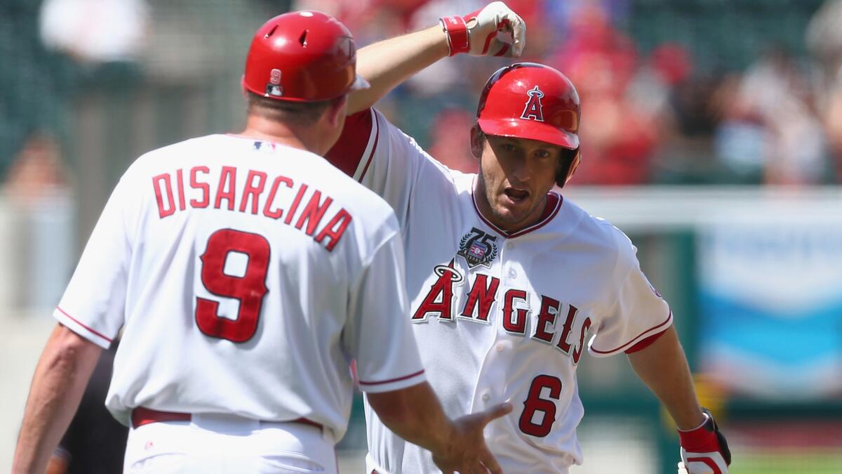 Angels third baseman David Freese, right, is congratulated by third base coach Gary DiSarcina after hitting a solo home run against the Detroit Tigers on July 27.