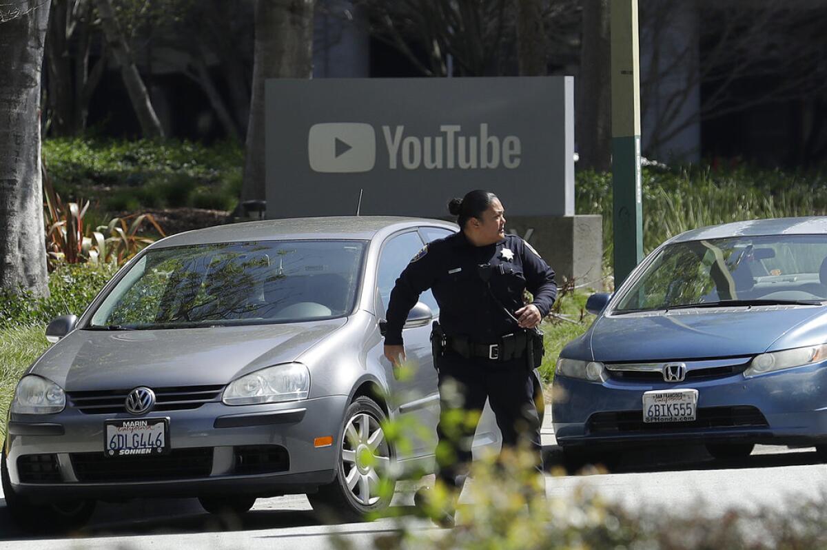 A police officer runs down a street at the YouTube complex in San Bruno, Calif., on Wednesday.