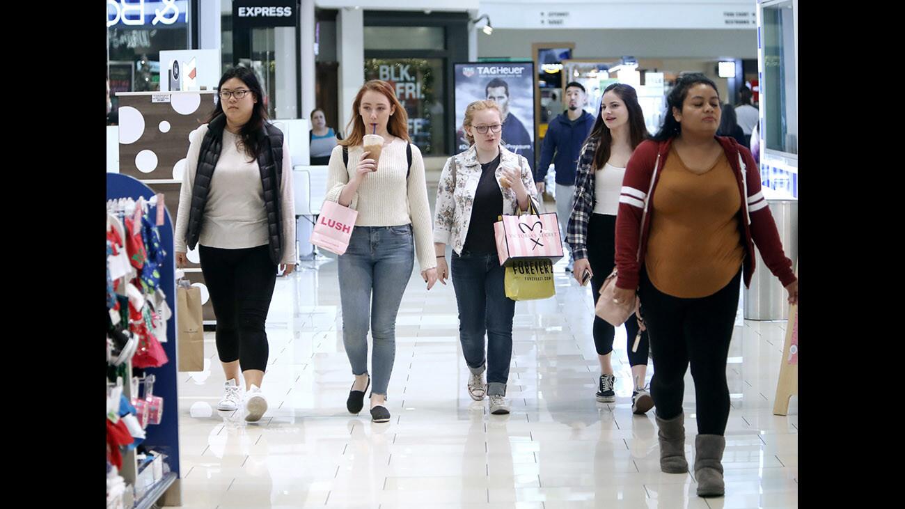 Shopping at the Glendale Galleria are, second from left Sabrina Wrabley, 21, her sister Jaden Wrabley, 16, center, and friend Mary Wood, 16, second from right, all from Burbank, early Black Friday morning, in Glendale on Nov. 24, 2017.