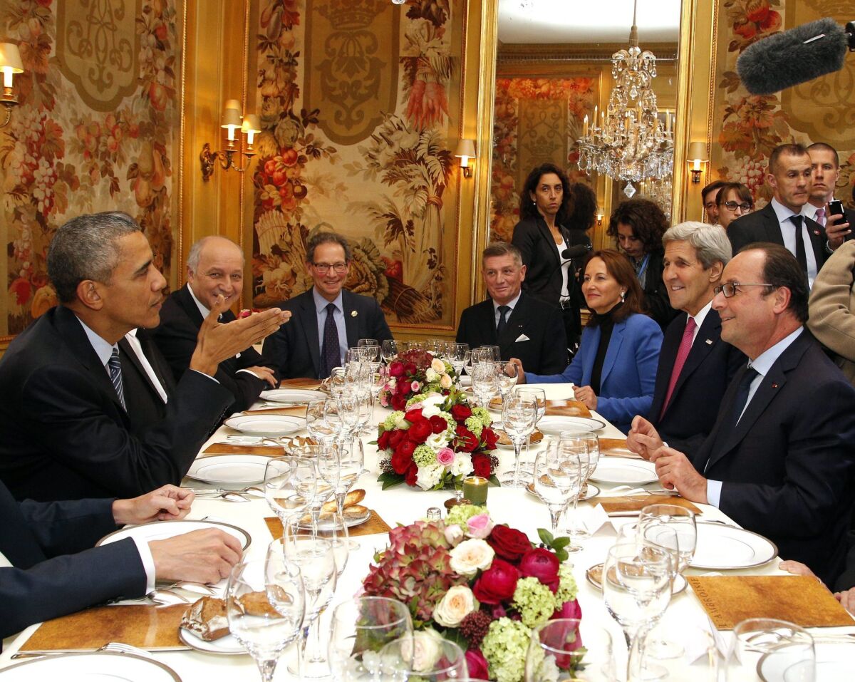 President Obama sits with French President Francois Hollande (right), Secretary of State John Kerry, and other officials as they have dinner at the Ambroisie restaurant in Paris on Nov. 30.