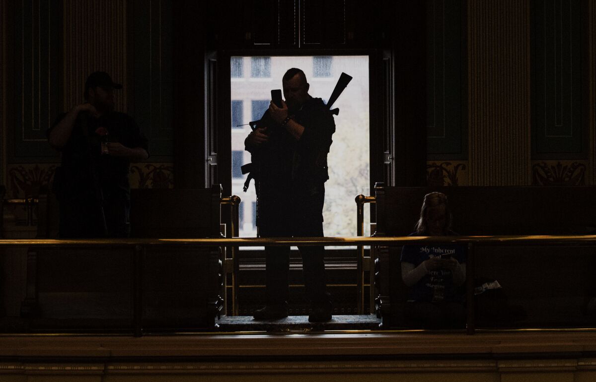 Militia members wait inside the Senate chamber at the Capitol building during the "American Patriot Rally on Capitol Lawn" protest in Lansing, Mich., Thursday April 30, 2020, during the coronavirus outbreak. Experts say far-right groups in the U.S. are taking a more dangerously radical turn as four men go on trial in an alleged scheme to kidnap Michigan's governor. (Nicole Hester/Mlive.com/Ann Arbor News via AP, File)