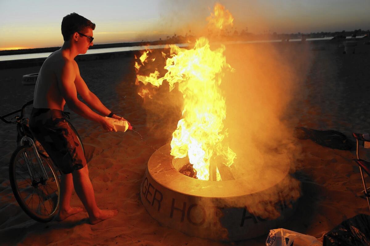 A bonfire at Corona del Mar State Beach; the South Coast Air Quality Management District says Newport Beach's charcoal- and wood-burning fire rings are in compliance with the rules.