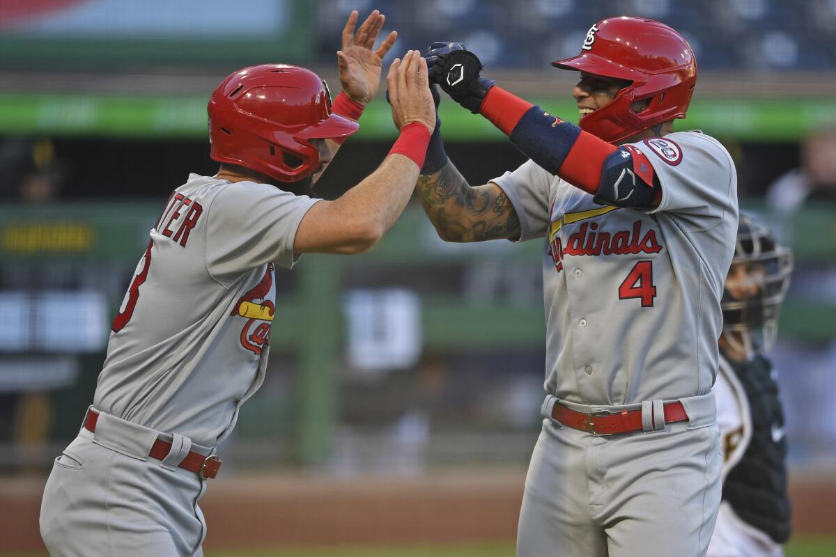 Yadier Molina de los Cardenales de San Lui9s celebra con Matt Carpenter tras lanzar un jonrón