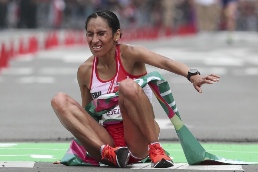 Gladys Tejeda of Peru falls after crossing the finish line to win the women's marathon at the Pan American Games in Lima, Peru, Saturday, July 27, 2019. (AP Photo/Martin Mejia)