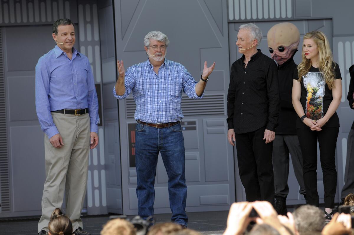 Ashley Eckstein stands on stage with Robert Iger, George Lucas and Anthony Daniels.