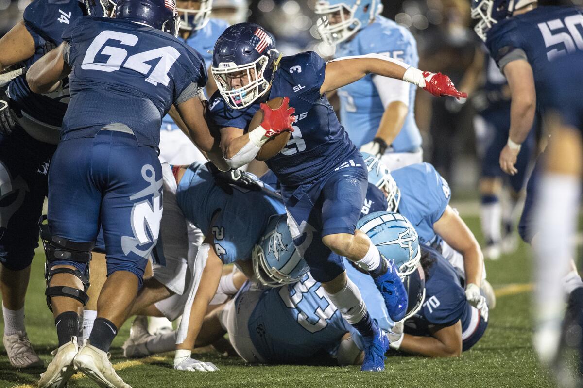 Newport Harbor's Justin McCoy carries the ball during the Battle of the Bay football game against Corona del Mar.