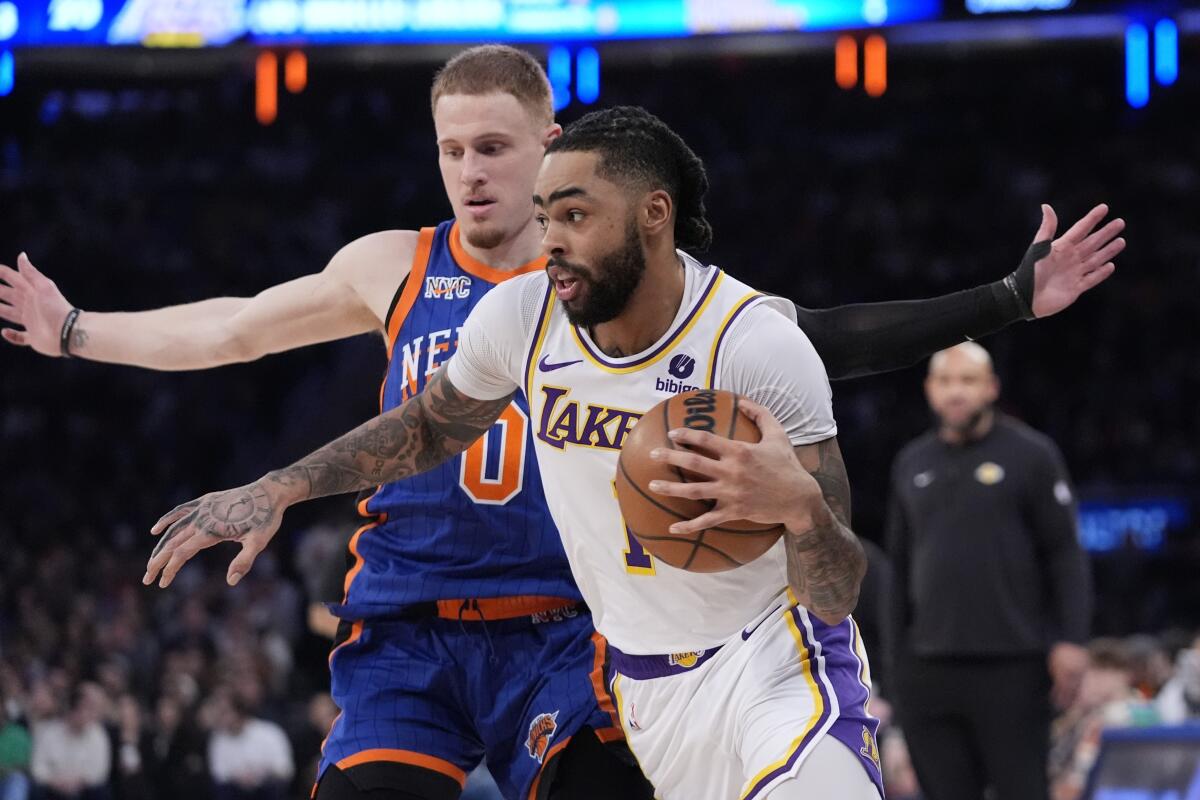 Lakers guard D'Angelo Russell drives past New York Knicks guard Donte DiVincenzo during the first half.