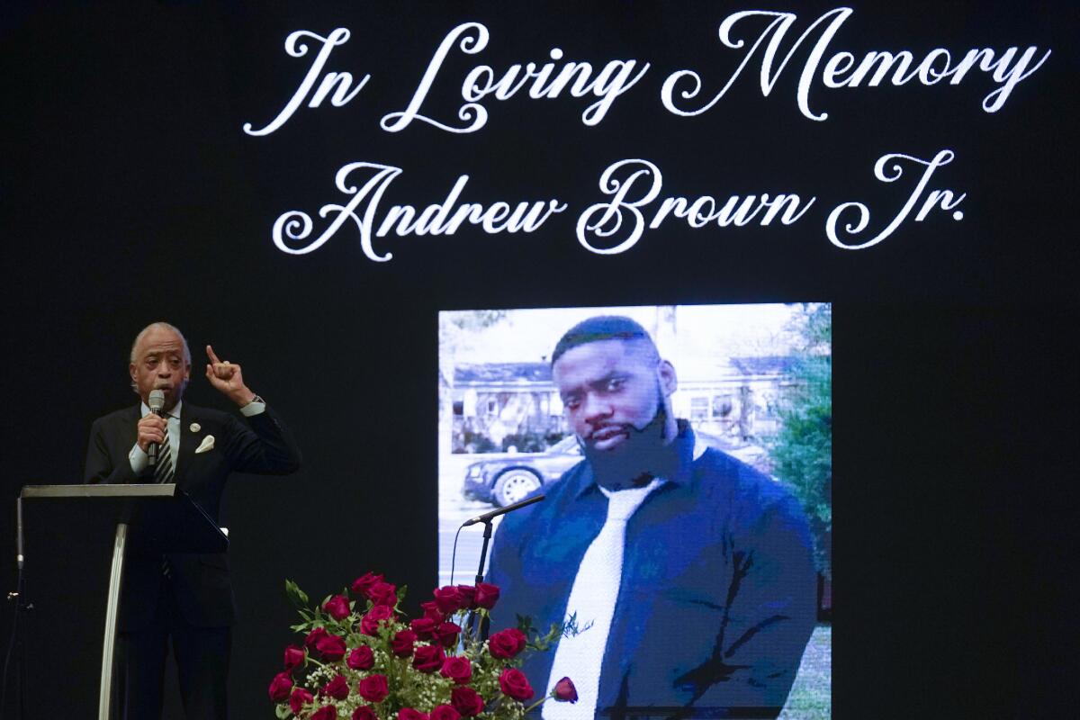 The Rev. Al Sharpton speaks in front of a photo of Andrew Brown Jr.