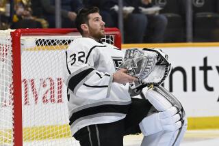 Los Angeles Kings goaltender Jonathan Quick (32) holds his mask during a timeout in the second period.