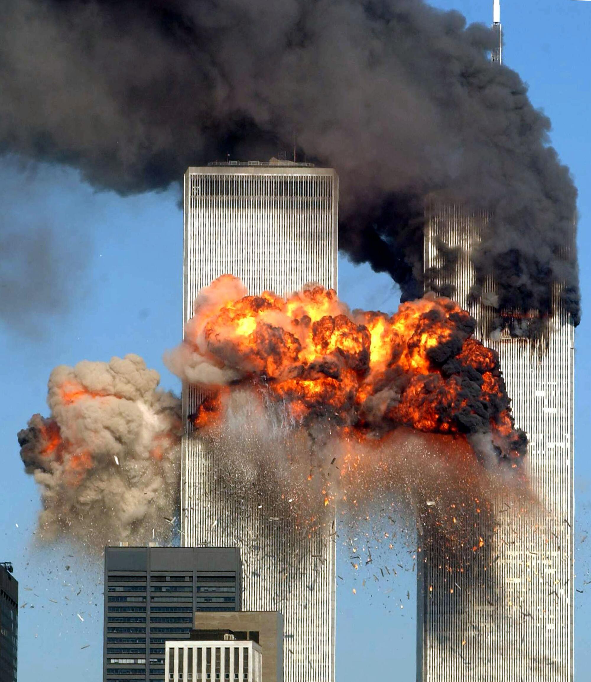 An explosion from a tower at left, and black smoke pouring from tower at right