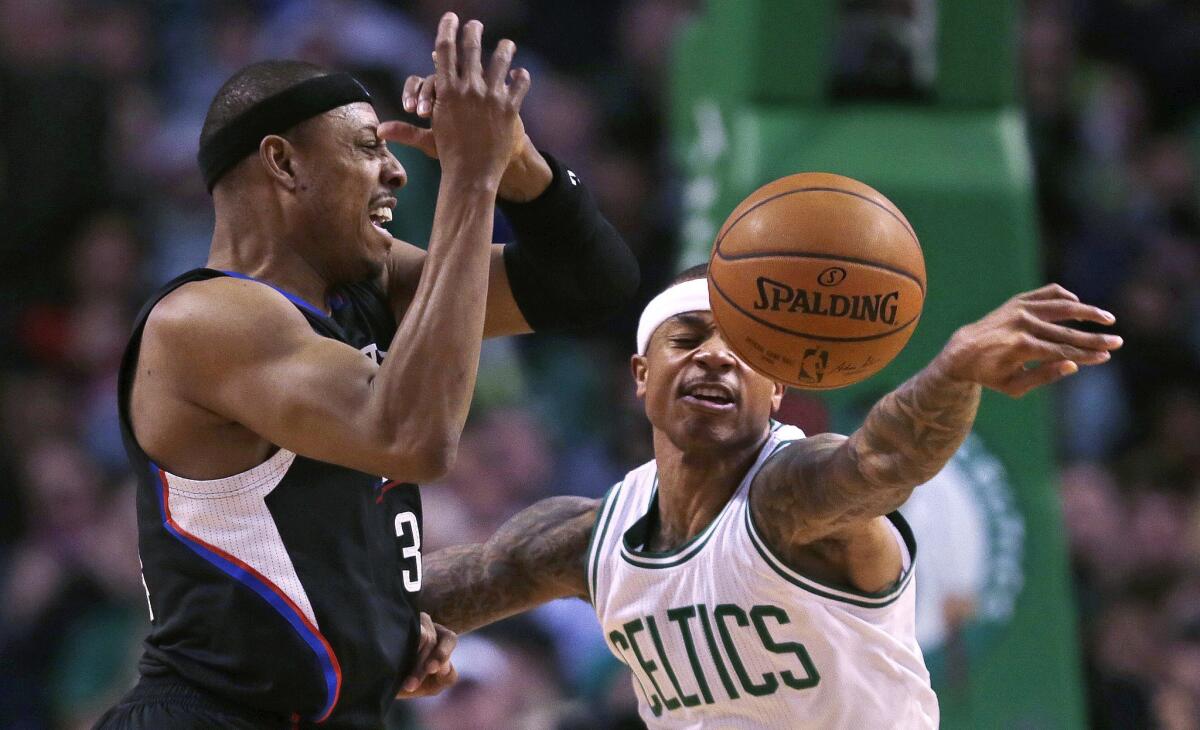 Celtics guard Isaiah Thomas, right, knocks away a pass to Clippers forward Paul Pierce during the first quarter of a game on Feb. 10.