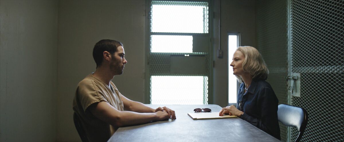 Tahar Rahim and Jodie Foster sit at a table