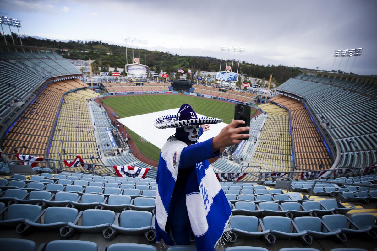 A man takes a photo at Dodger Stadium.