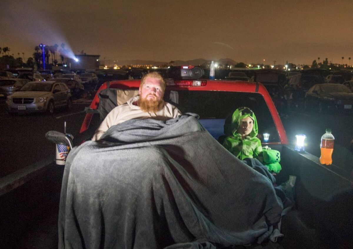 A.J. Page and son Jaxson, 5, of San Diego, watch a movie from the bed of their truck at the Van Buren Drive-In in Riverside.