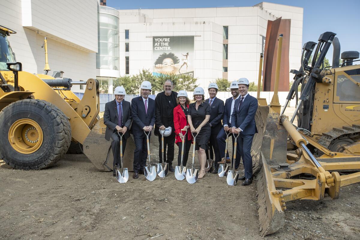 Craig Wells, Anton Segerstrom, Thom Mayne, Annette Wiley, Katrina Foley, Mark Perry, Carlos Gonzalez and Todd Smith, from left, break ground for the Orange County Museum of Art's new home in Costa Mesa on Sept. 20.