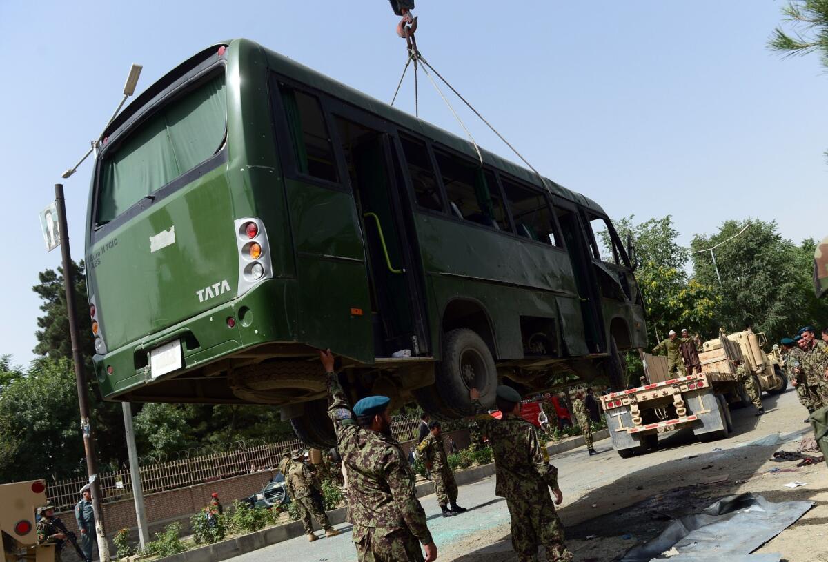 Afghan soldiers assist as a crane lifts a military bus damaged in a suicide bombing Wednesday in Kabul.