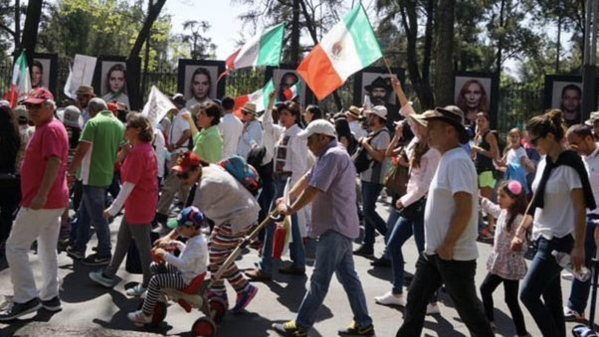 Marchers in Mexico City along Paseo de la Reforma protest the immigration and trade policies of President Trump. Mexican police said more than 20,000 people participated in the peaceful march Sunday.