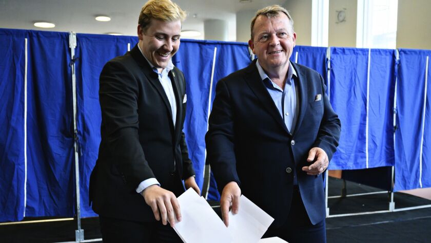Danish Prime Minister Lars Loekke Rasmussen, right, and his son Bergur Loekke Rasmussen from the Liberal Party vote in the European Parliament election Sunday at Nyboder School in Copenhagen.