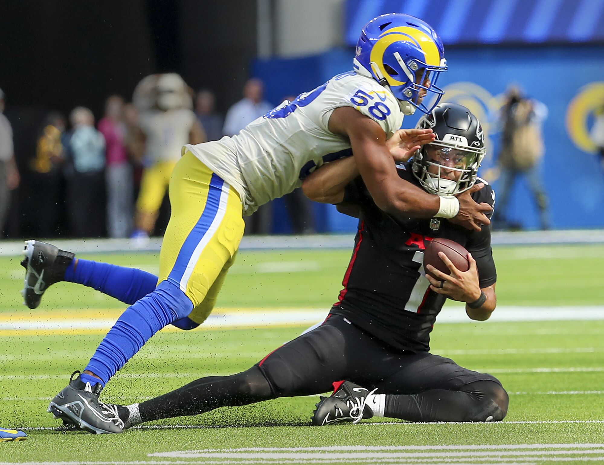 Rams defensive lineman Justin Hollins tackles Falcons quarterback Marcus Mariota late in the fourth quarter.