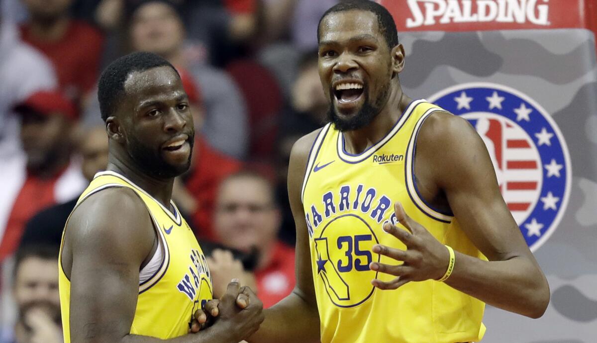 Golden State Warriors forwards Kevin Durant (35) and Draymond Green appear to put their differences aside during a game in Houston on Nov. 15.