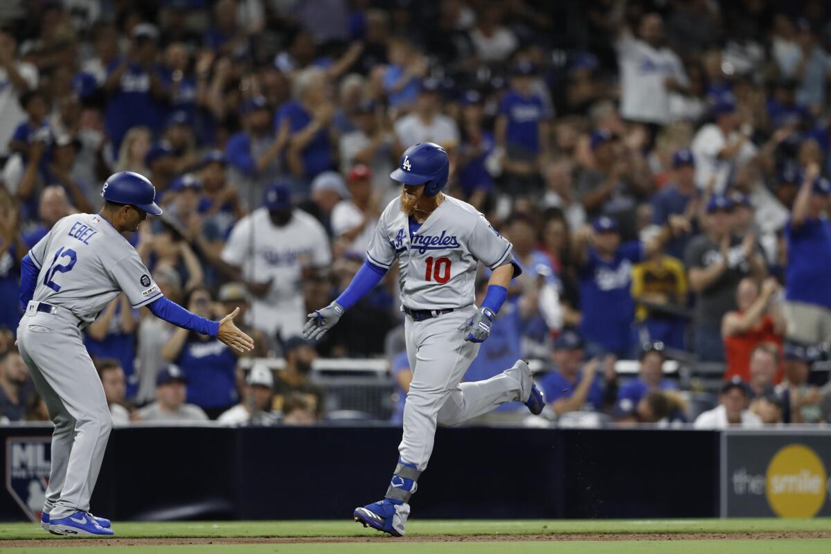 Justin Turner is congratulated by Dodgers third base coach Dino Ebel after hitting a home run during the third inning Monday.