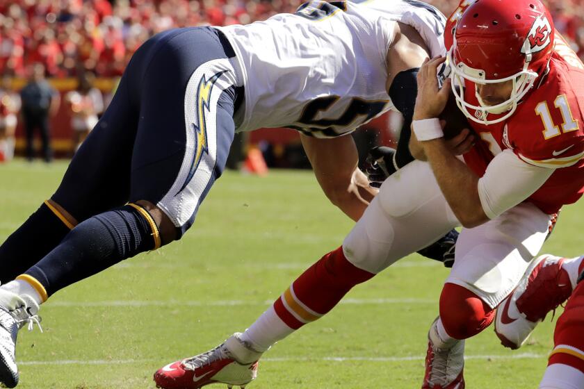 Chiefs quarterback Alex Smith dives past Chargers linebacker Tourek Williams to score the game-winning touchdown Sunday.