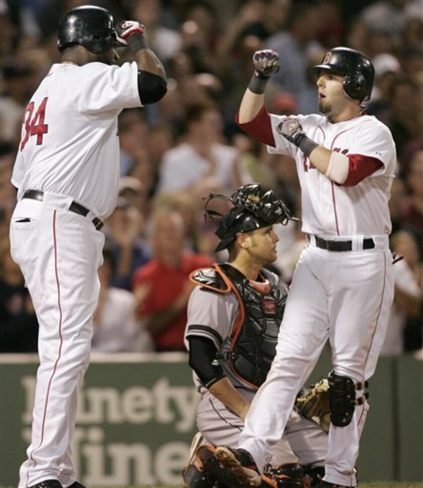 Boston Red Sox's David Ortiz, left, welcomes home teammate Dustin Pedroia, right, after Pedroia hit a three-run home run off a pitch by Baltimore Orioles' Fernando Cabrera in the fourth inning of a baseball game at Fenway Park, in Boston, Tuesday, Sept. 2, 2008. Orioles catcher Ramon Hernandez, center, looks away. (AP Photo/Steven Senne)