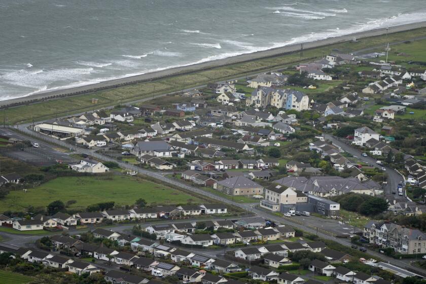 An aerial view of Fairbourne village in Gwynedd in Wales, Wednesday, Oct. 20, 2021. In north Wales, residents in the small coastal village of Fairbourne face being the U.K.'s first "climate refugees." Authorities say that by 2054, it would no longer be sustainable to keep up flood defenses there because of faster sea level rises and more frequent and extreme storms caused by climate change. (AP Photo/Kirsty Wigglesworth)